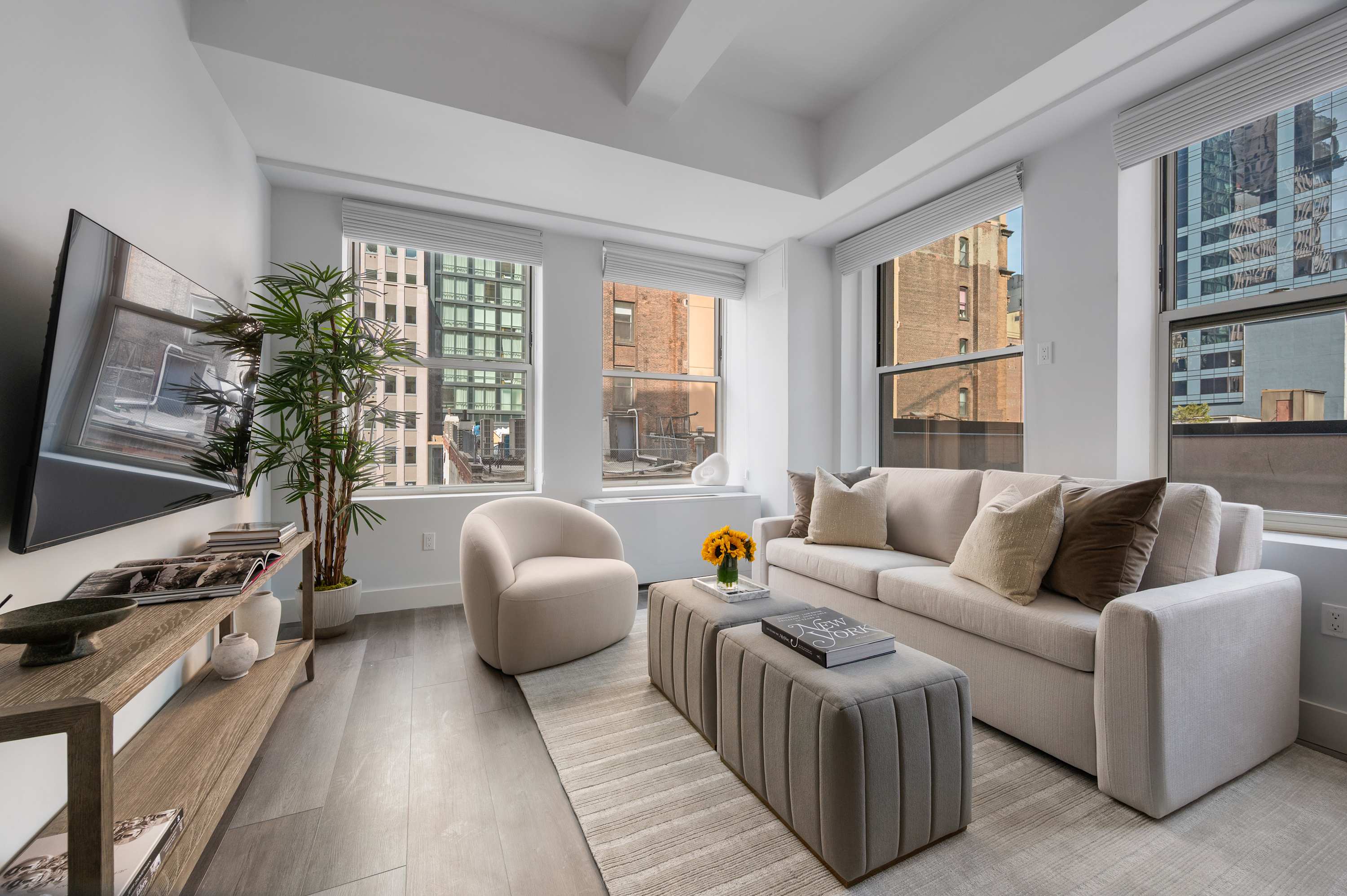 A suite living room with a sofa, armchair, and large windows