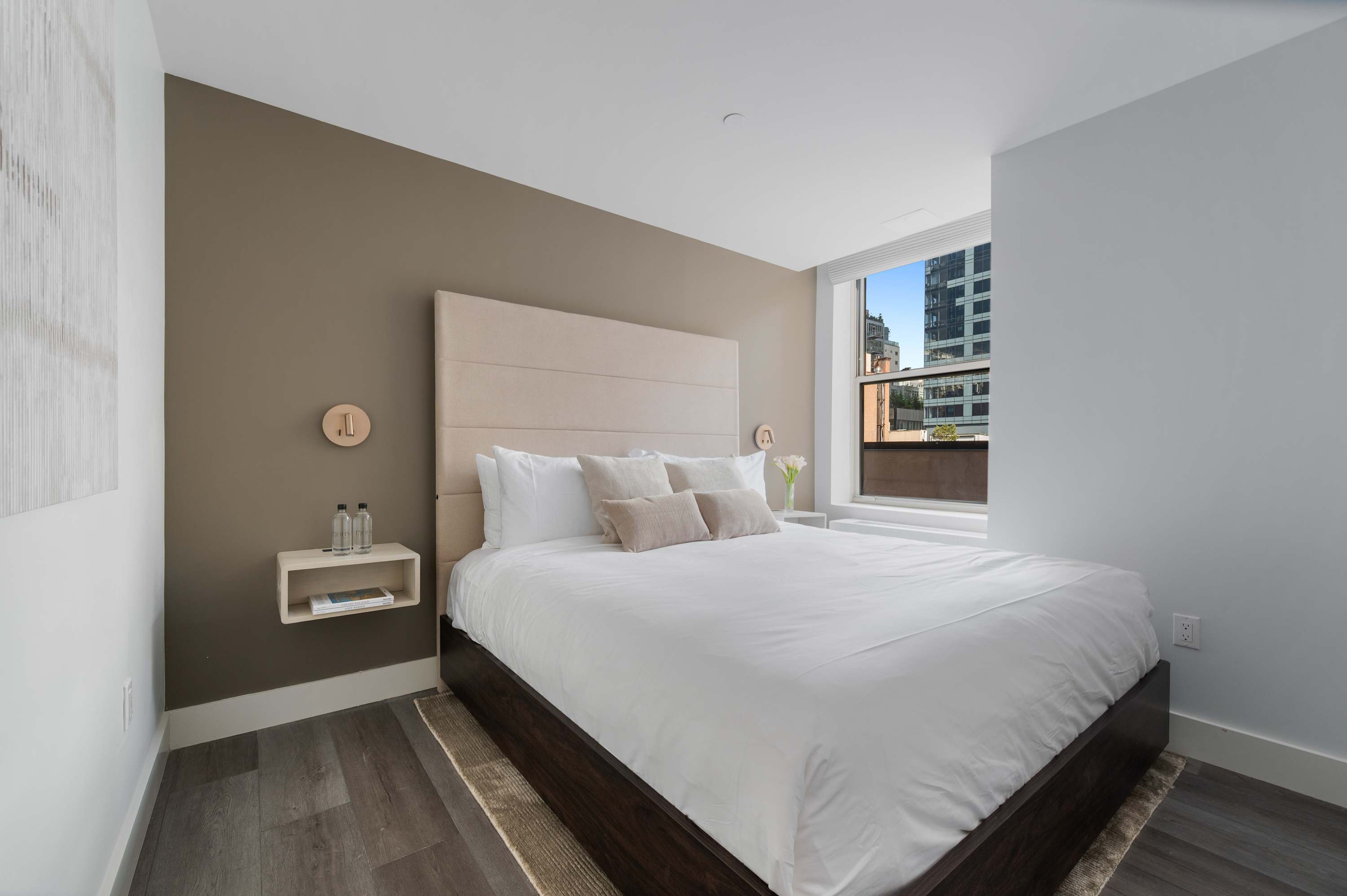 Bedroom in a suite at 17John with a window looking over the Financial District.