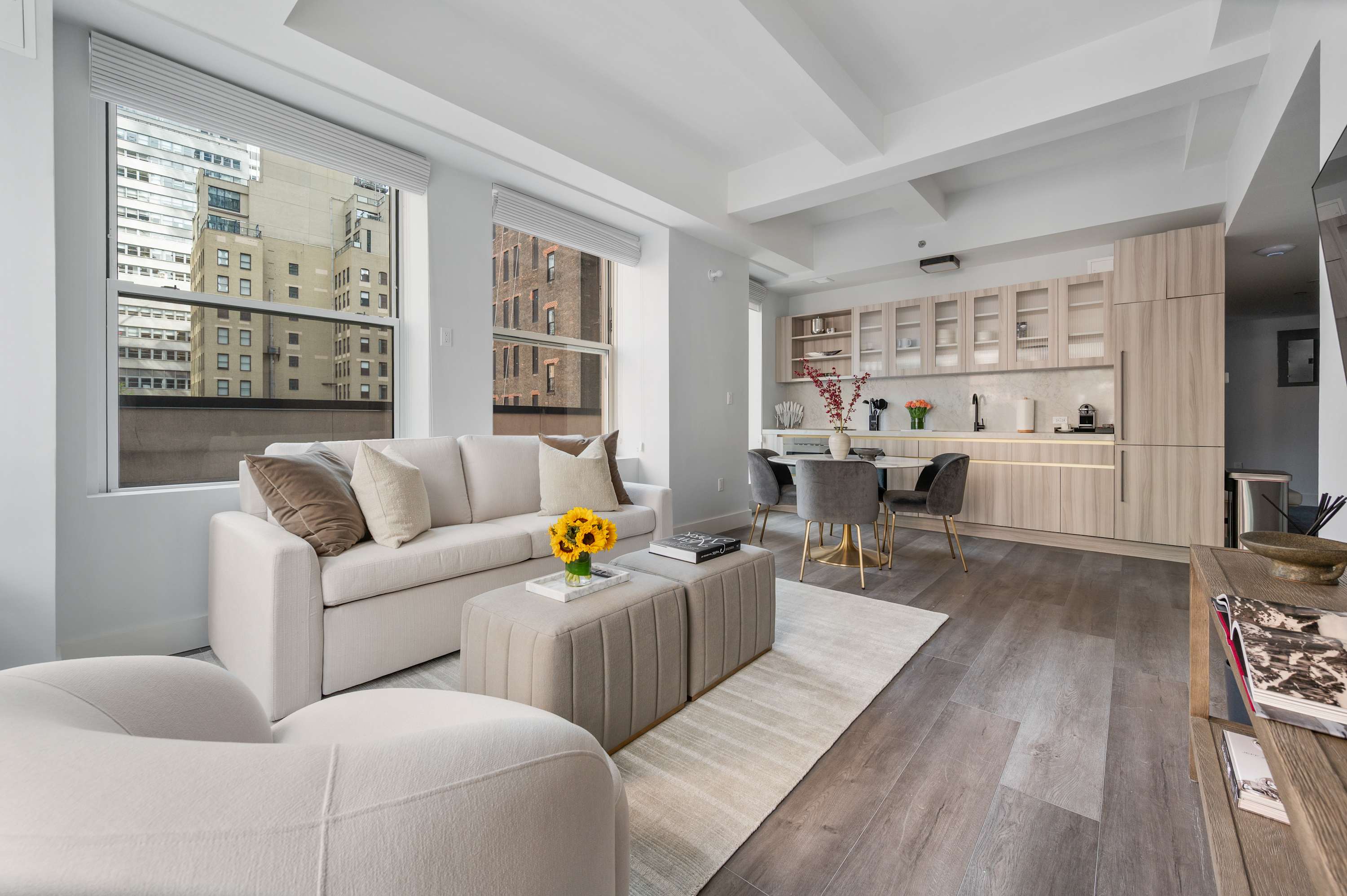 Suite living room with a white couch, wooden floor, and large window.