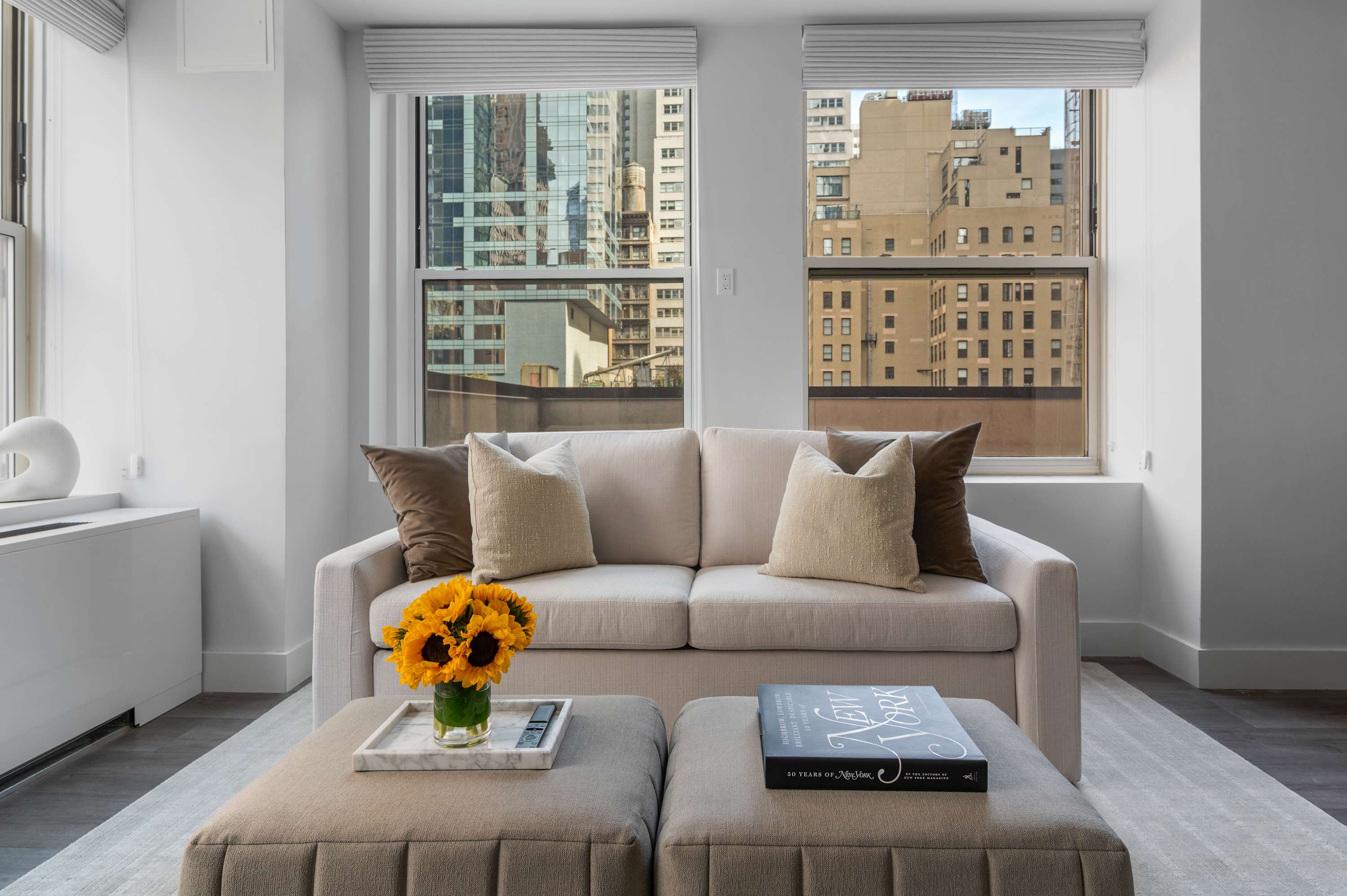 Suite living room with a beige couch and a city view.