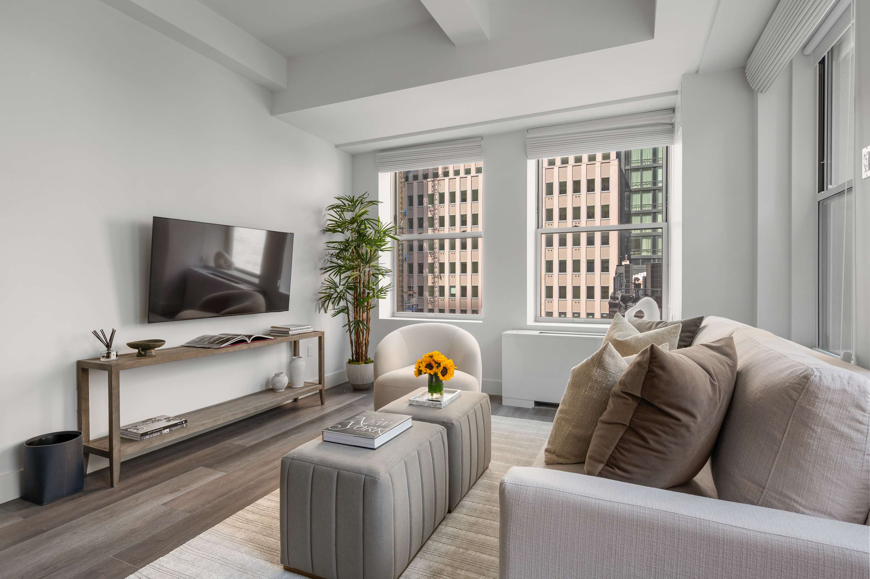 Suite living room with a couch, TV, and a window looking out over the city.