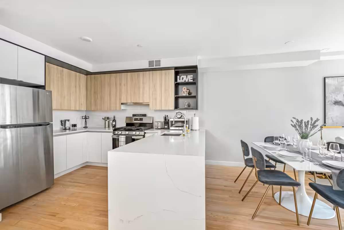 Apartment kitchen with white marble countertops and wood floors at The Sixty Two.