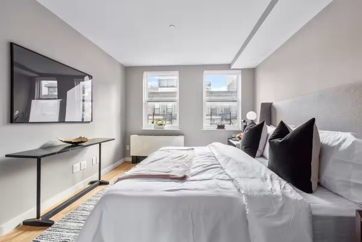 Bedroom with white walls, wooden floor, and a large bed at The Sixty Two.