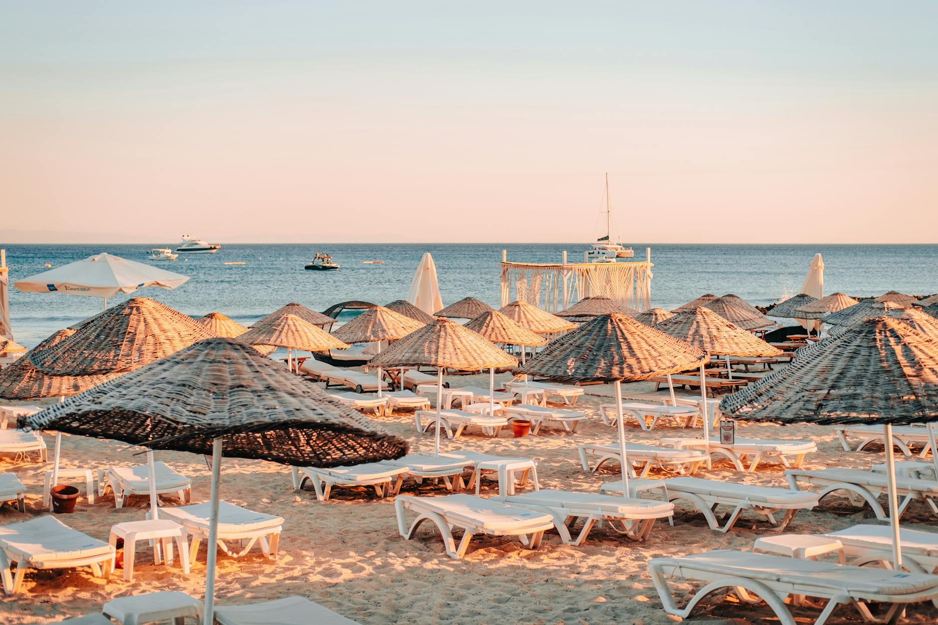 Sunbeds and umbrellas facing a calm sea in the early morning