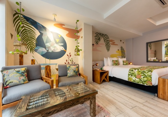Una habitación con una cama, sillas y una mesa de café