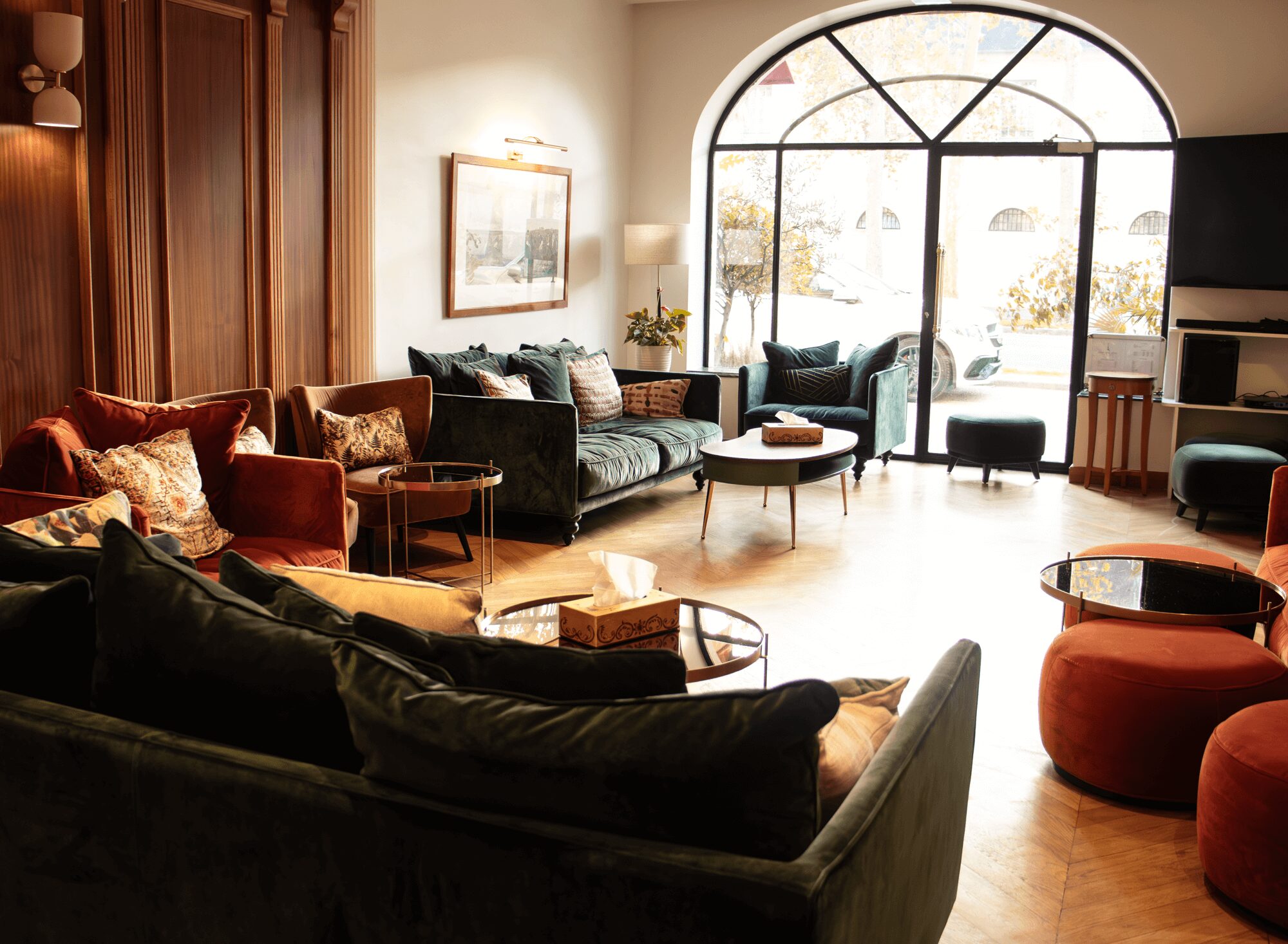 Lounge with green sofas, parquet floor and large windows, used for our meetings.