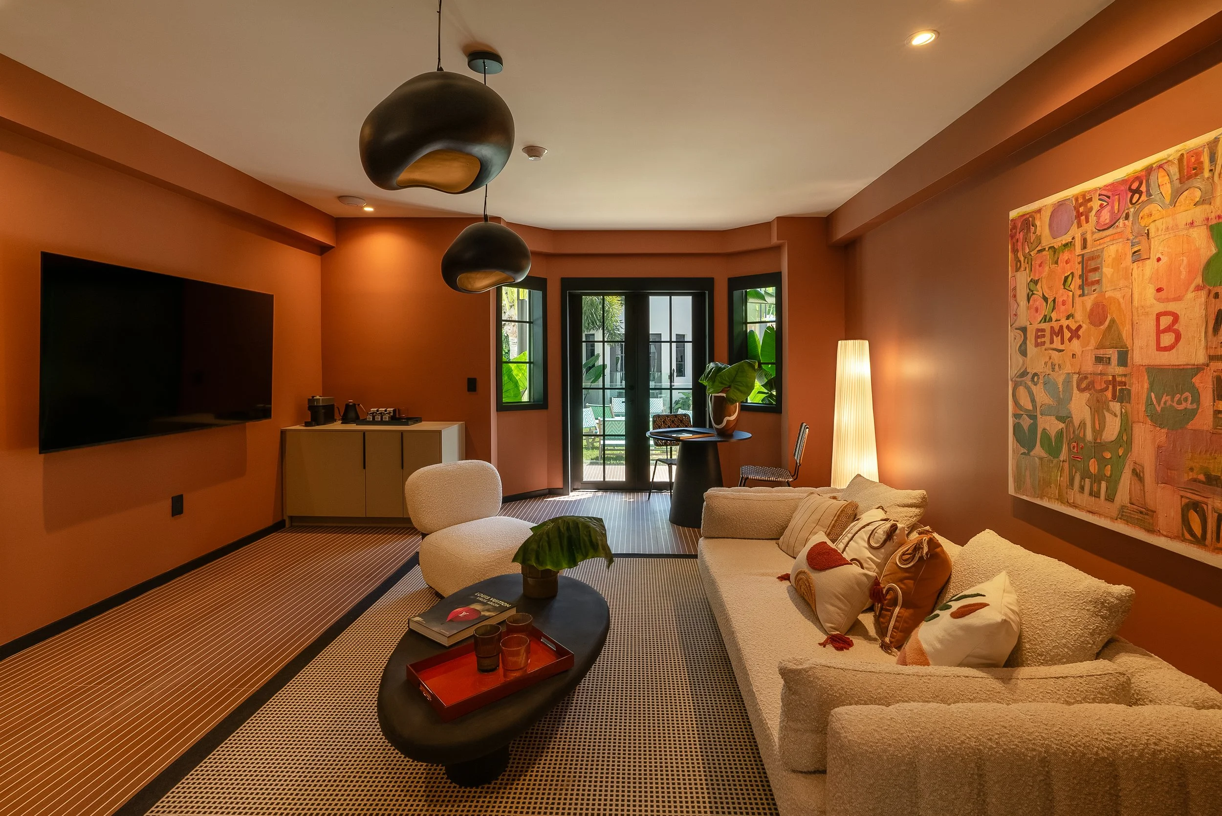 Living room of the Grand Luxe Suite with orange walls, a large couch and a coffee table