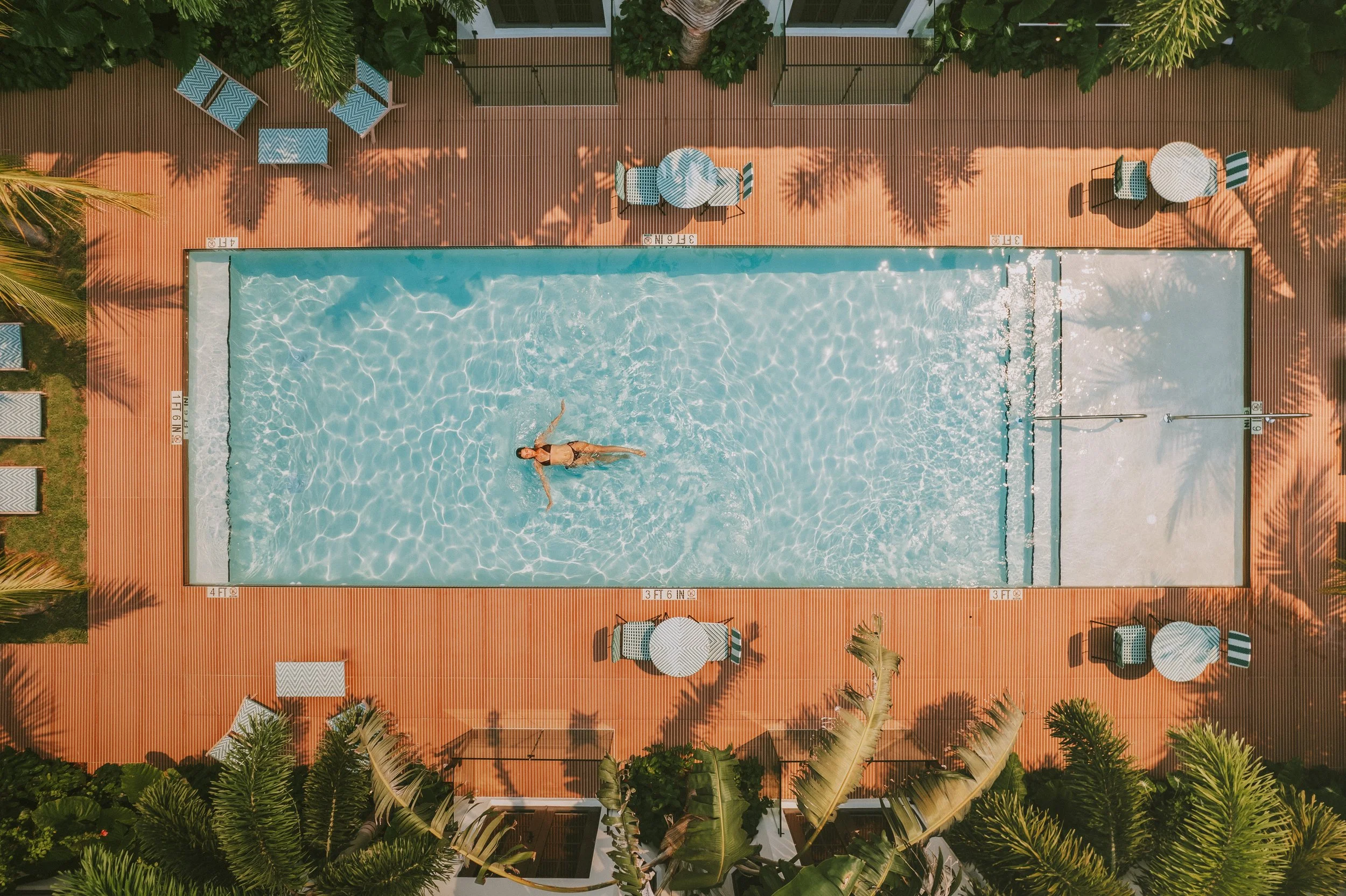 The courtyard pool at Maison Felix, seen from above, with one swimmer in the water