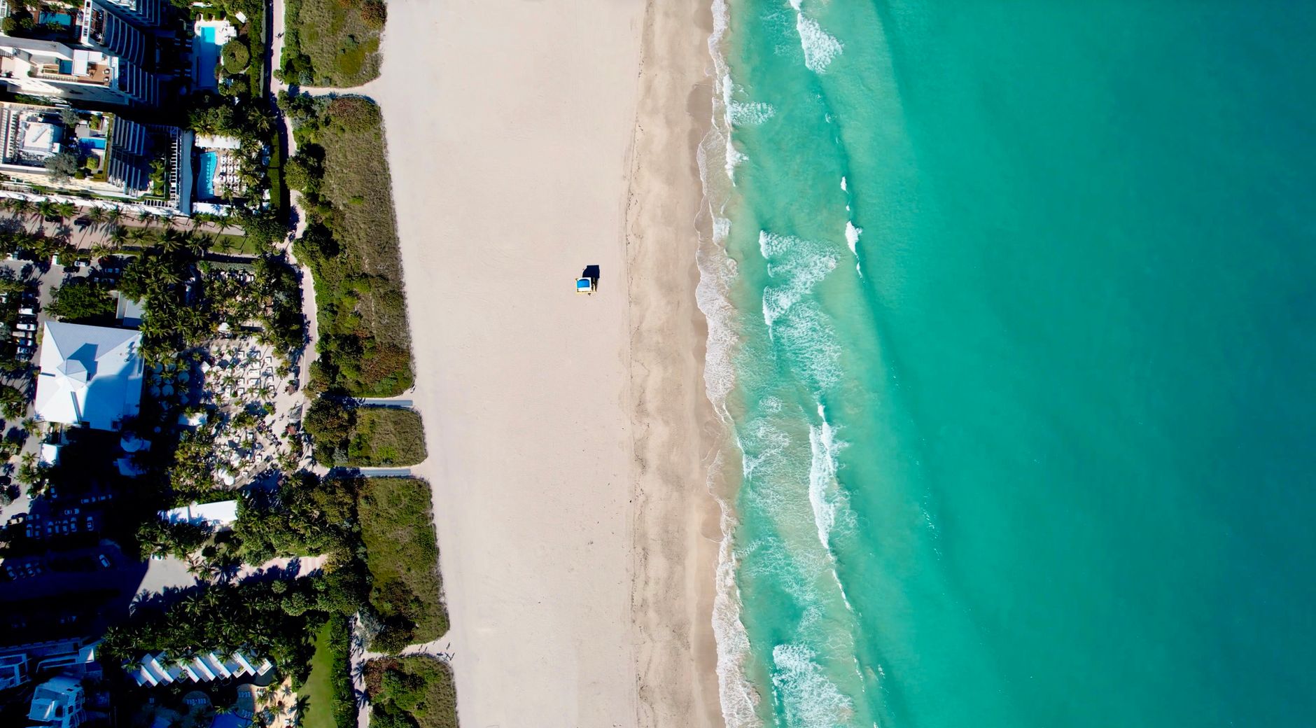 Aerial view of the Miami Beach coastline, turquoise water along the sand.