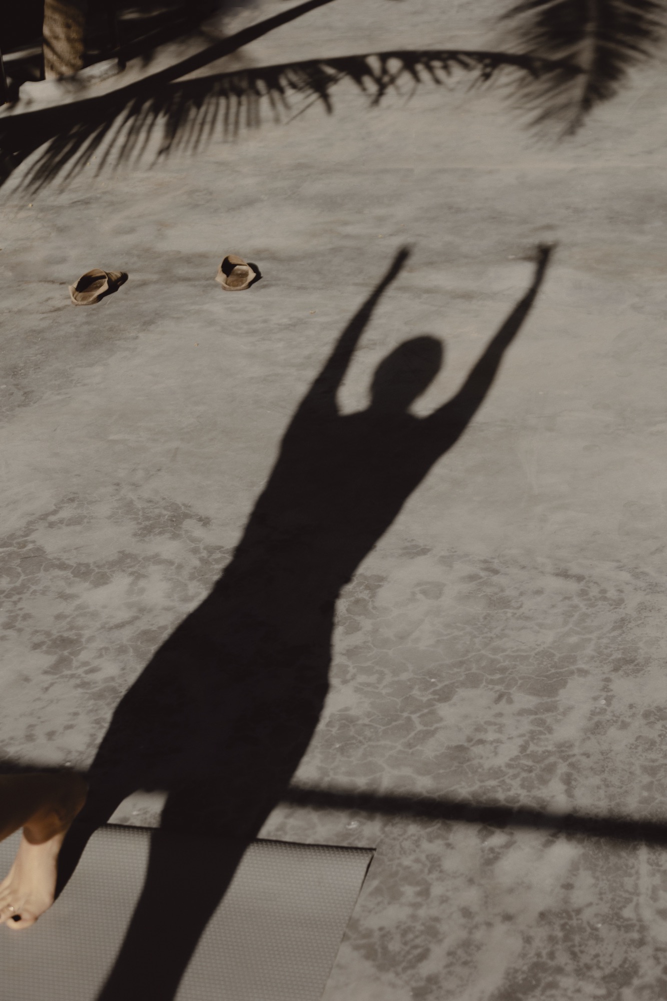 Shadow of a person doing yoga on the beach at UMi Tulum