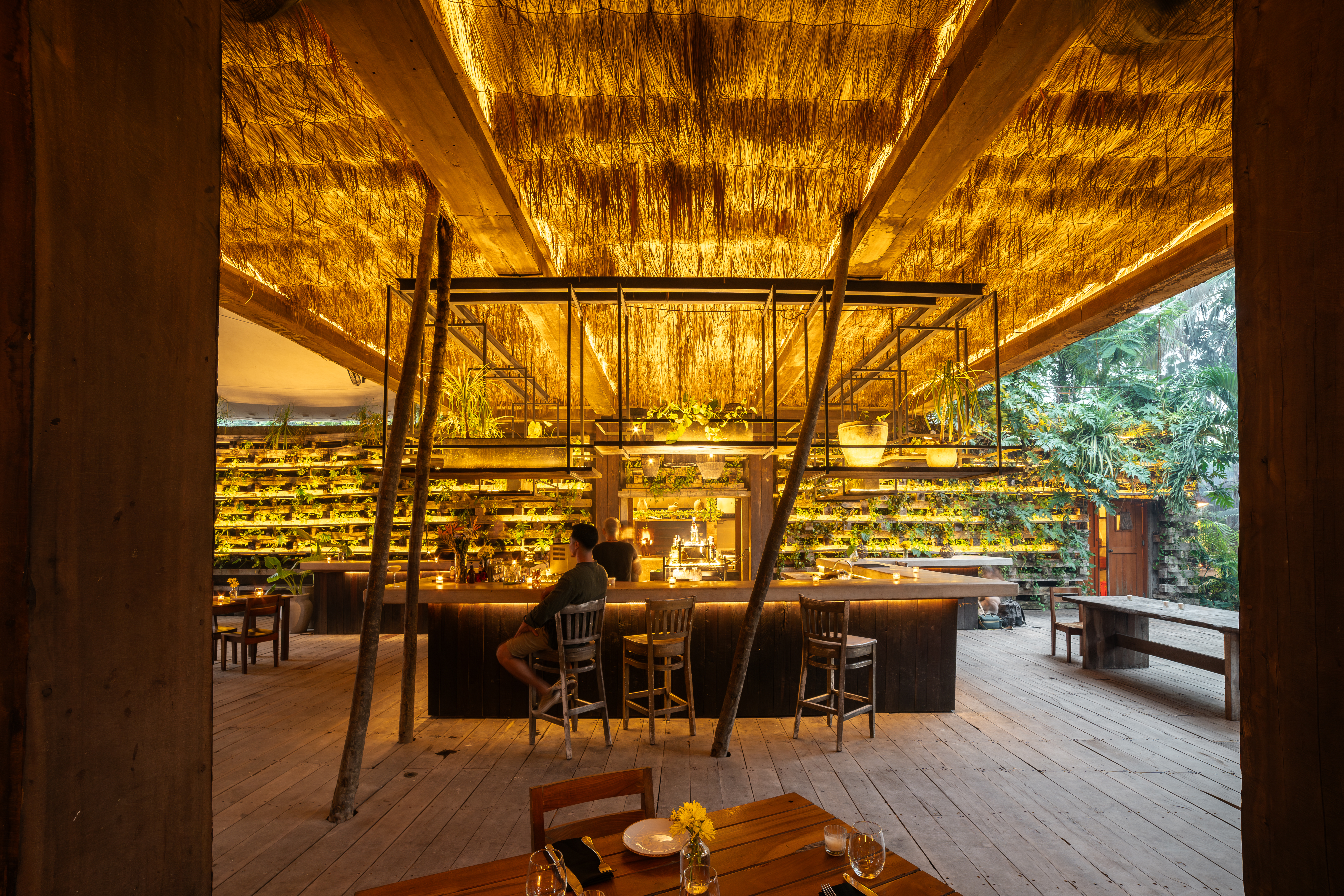 NÜ Tulum open-air dining room and bar under a thatched roof in the jungle