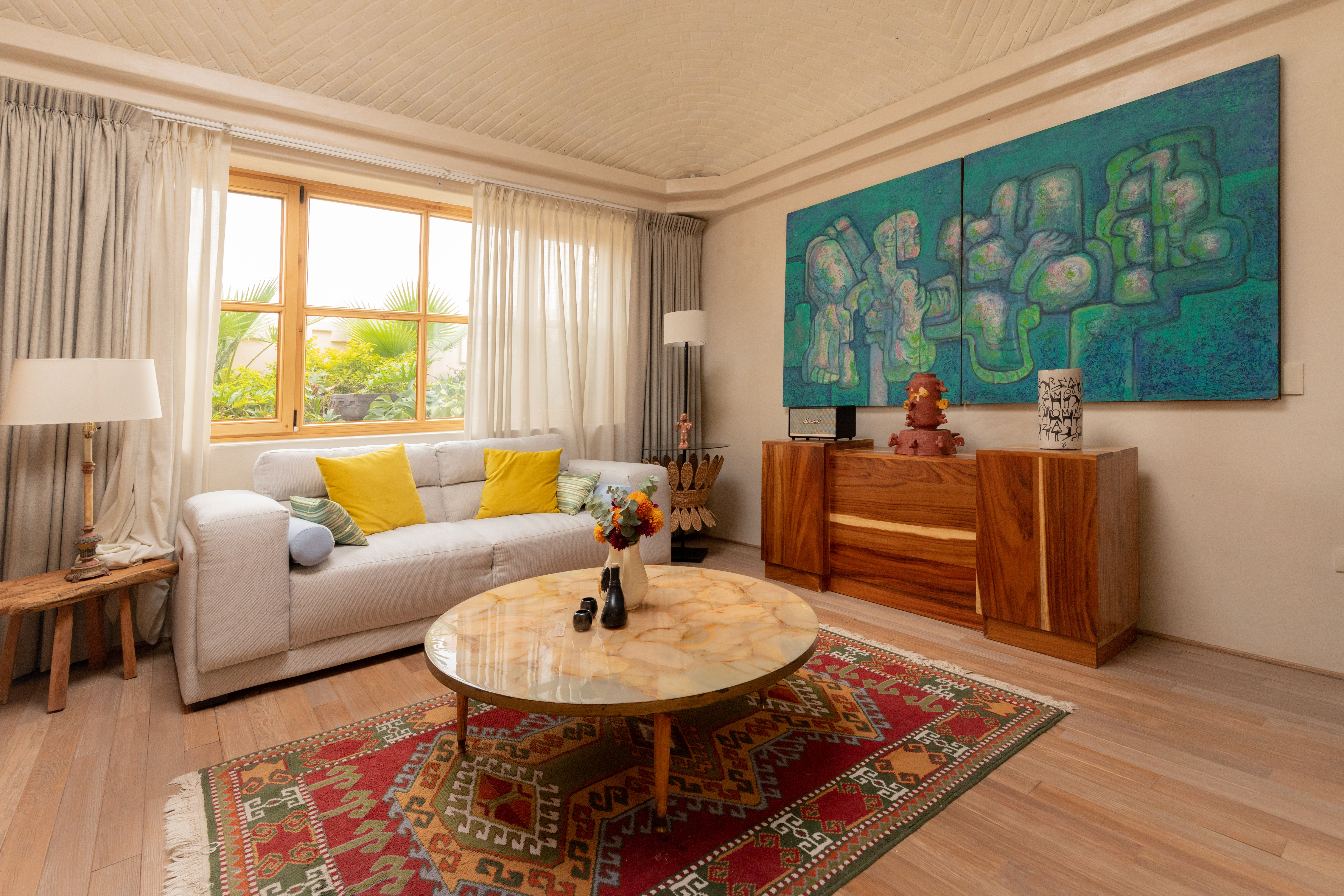 Master Suite living room with sofa, onyx coffee table and a large turquoise artwork at La Valise San Miguel de Allende
