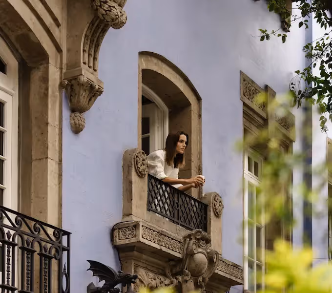 A guest on a suite balcony at La Valise Mexico City, looking out over Roma Norte's older facades