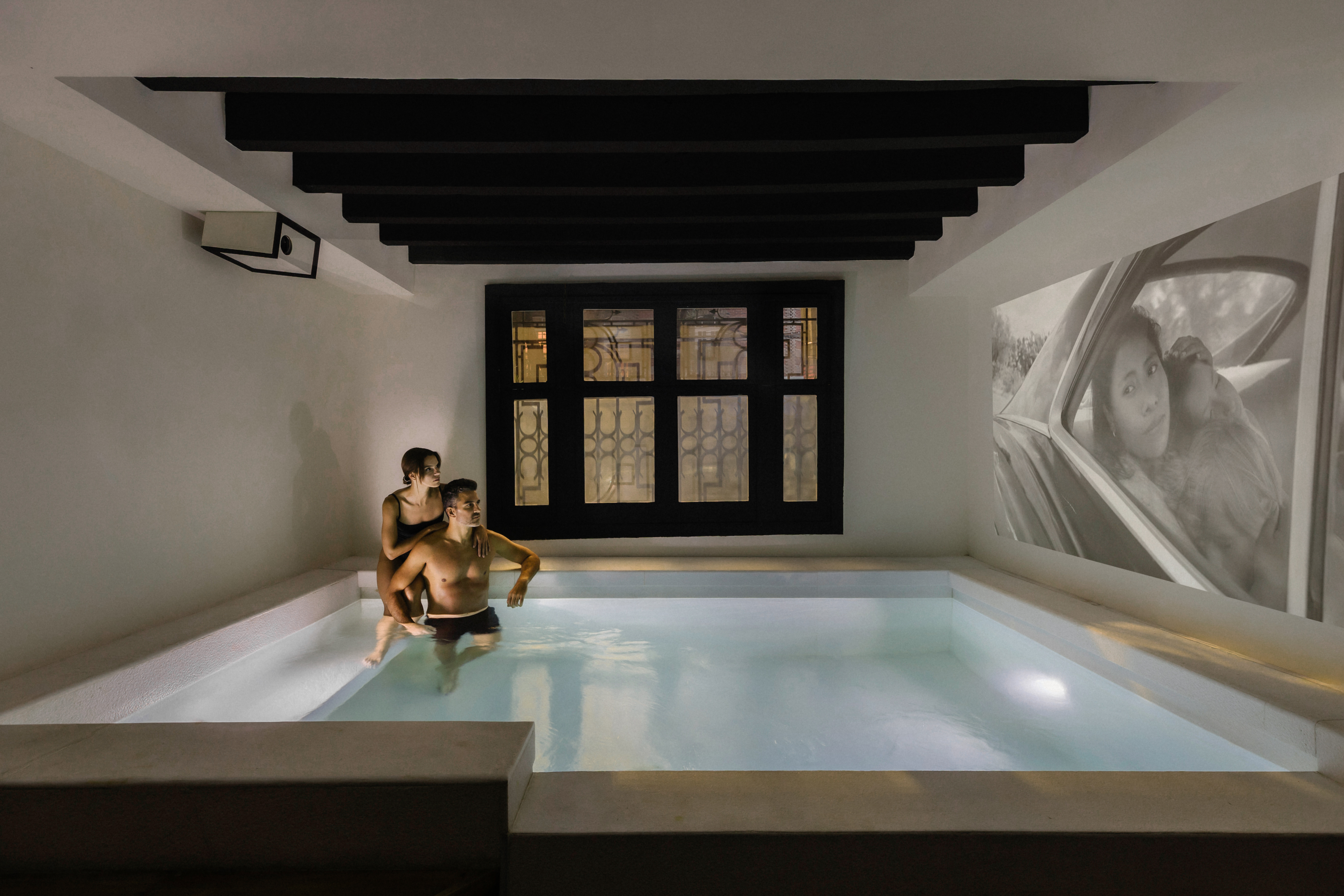 Couple in the illuminated indoor pool of the Pis-cinema at La Valise Mexico City