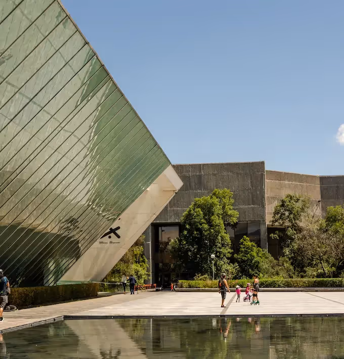 Slanted glass façade and reflecting pool of the MUAC contemporary art museum in Mexico City